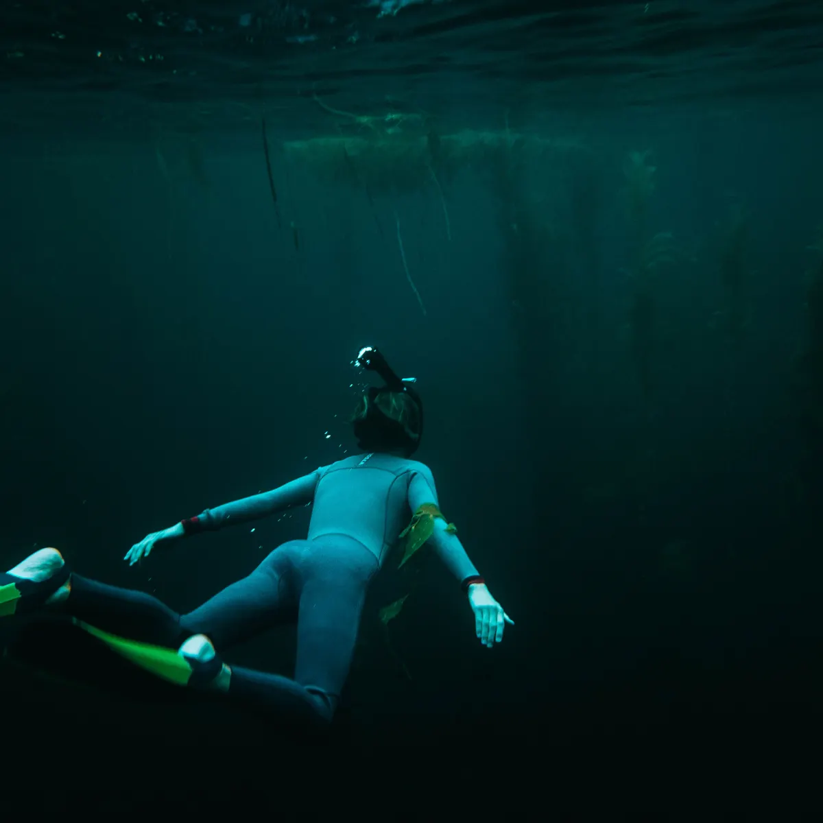 shane-stagner-wVvxjiLJr-g-unsplash A woman snorkeling through dark water