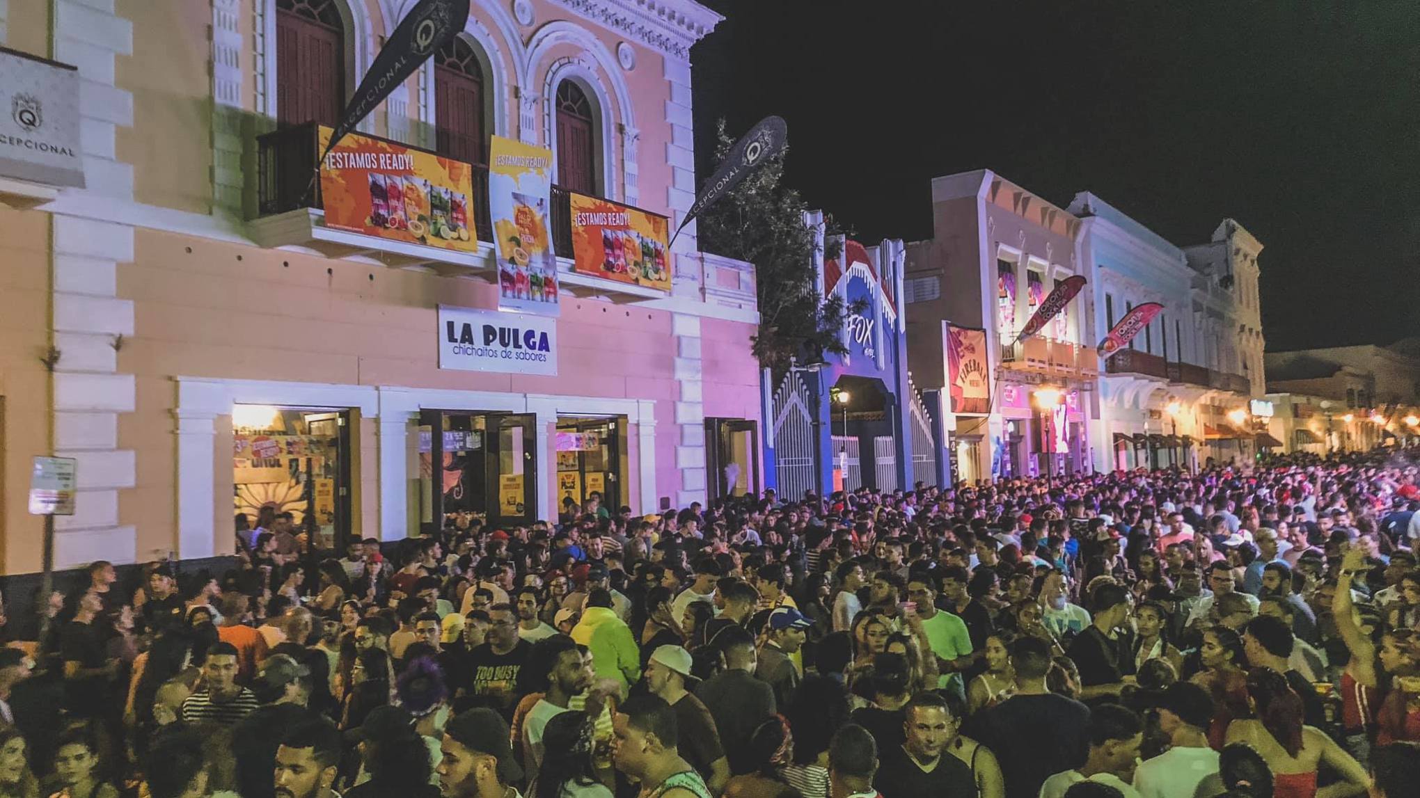 A crowd of people gathered outside a bar in San Juan
