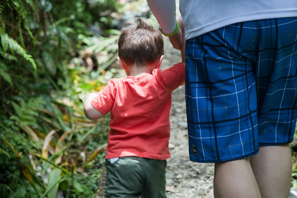 a young boy standing next to a child