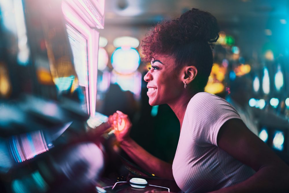 happy woman gambling at casino playing slot machine