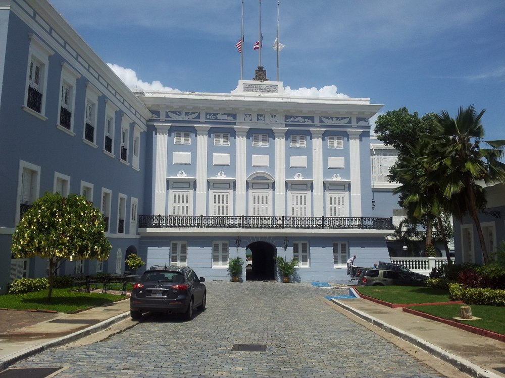 a large building with a clock on the side of a road