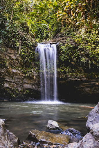 a large waterfall over a body of water with Falls of Falloch in the background